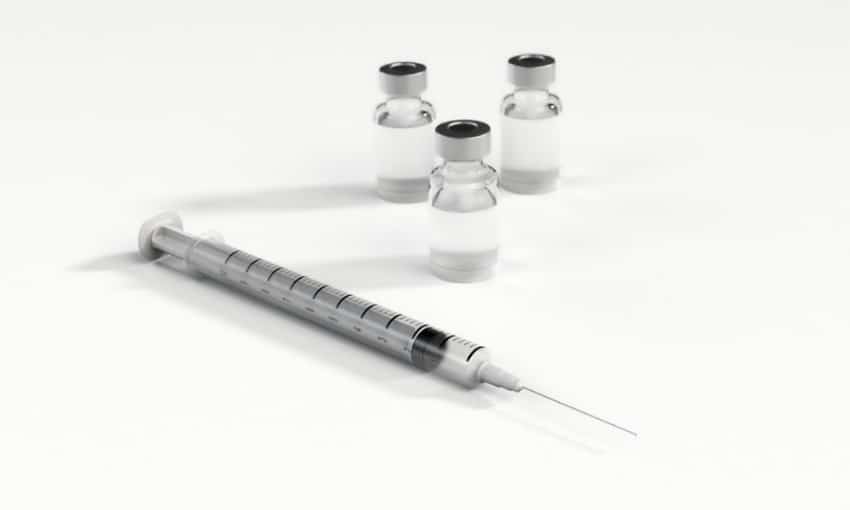 seringue à coté d'ampoules de vaccin