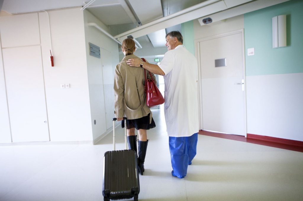 Photo d'un professionnel de santé accompagnant une patiente à la sortie de l'hôpital