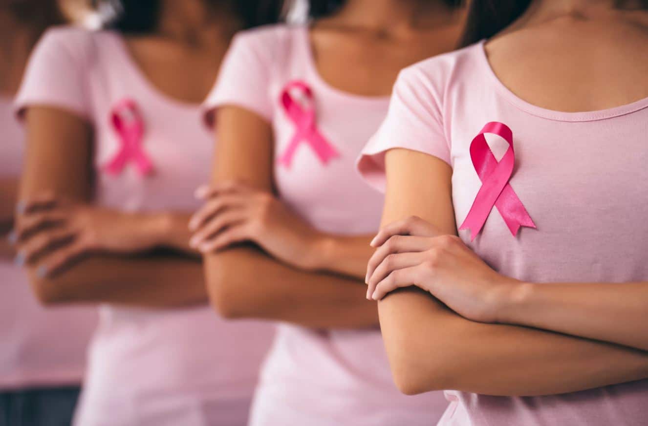 3 femmes portant le ruban rose symbole de lutte contre le cancer